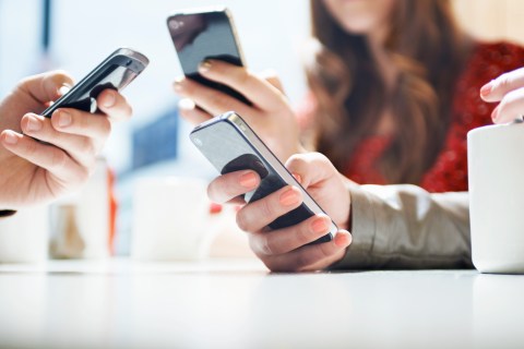 Hands texting on smartphones
