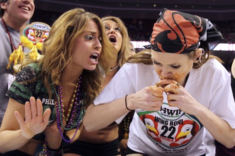 From left: A wingette cheers on contestant Molly Schuyler, of Omaha, Neb., during the Sportsradio 94 WIP's Wing Bowl 22 held at the Wells Fargo Center in Philadelphia, on Jan. 31, 2014.